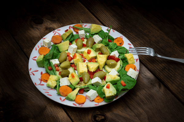 A colorful avocado salad with fresh vegetables, showcasing the vibrant greens and textures of a healthy, refreshing dish.