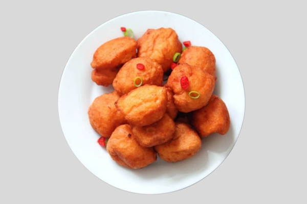 A plate of crispy Akara, golden fried bean cakes made from black-eyed peas, onions, and spices, a popular West African snack.